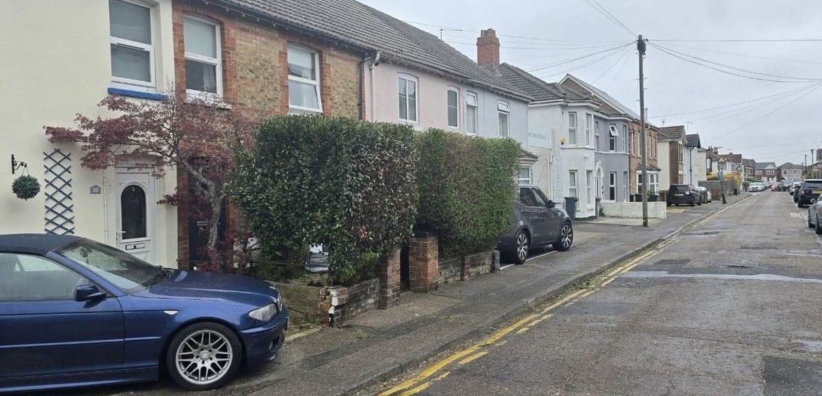 Terraced house front hedges trimmed into tidy blocks along the pavement